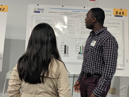 Two persons looking at a poster in a symposium