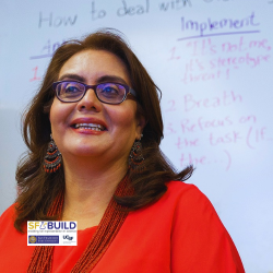 SF BUILD faculty member speaks to class with white board behind her.